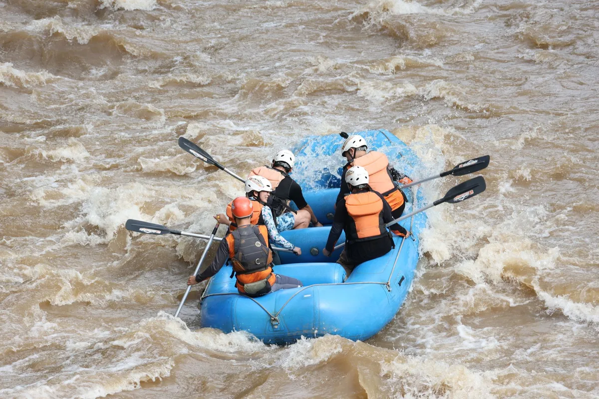 Nehirde rehber eşliğinde rafting ekibi